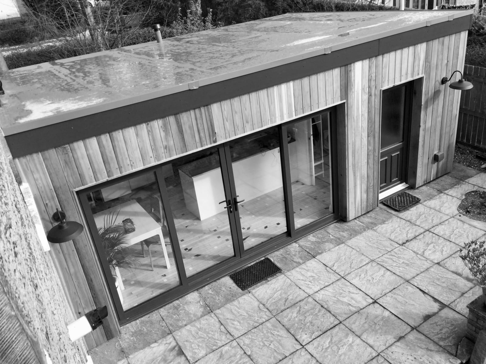 Extension to create kitchen, dining room, utility room and shower/toilet. Anthracite aluminium patio doors, cedar cladding, factre single membrane flat roof